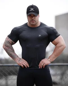 Close-up of a muscular man in a tight black short-sleeve fitness compression shirt.