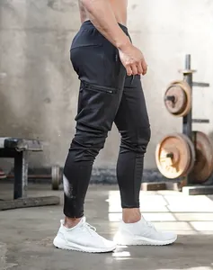 Detail shot of black slim-fit gym joggers with side zip pocket and tapered leg for fitness.