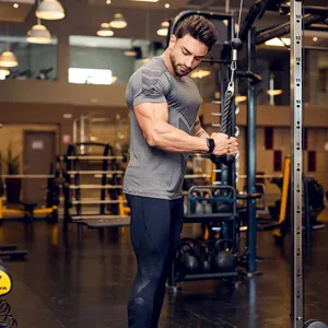 Detail shot of men's grey quick-dry compression T-shirt during triceps gym workout