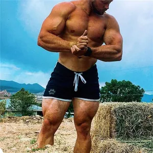 Hombre musculoso con pantalones cortos de fitness negros de secado rápido al aire