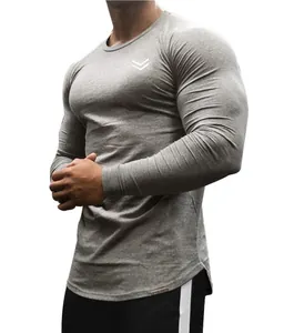 Dettaglio di una maglia da ginnastica a maniche lunghe grigia aderente per uomo.