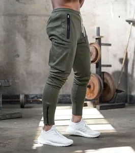 Side view of olive green cargo joggers for men with multi-zipper pockets in gym