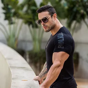 Detailed shot of a muscular male model wearing a black Bulking athletic t-shirt in garden