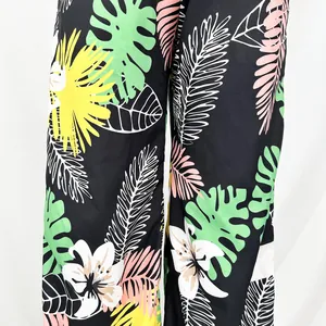 Detailansicht der lässigen Weithose mit lebhaften tropischen Blumen- und Blattmustern