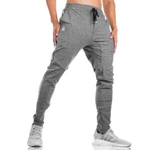 Detail view of men's grey slim fit workout joggers showing ankle zipper and logo