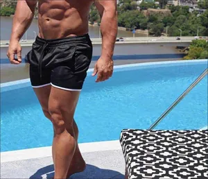 Nahaufnahme schwarzer schnelltrocknender Mesh-Sportshorts an muskulösem Model am Pool
