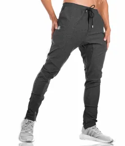 Detailed macro shot of men's charcoal grey slim-fit joggers with functional ankle zippers.