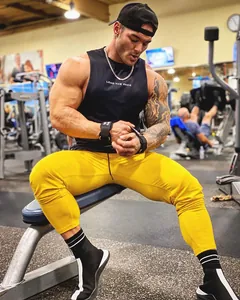 Detailed view of breathable black muscle tank top with Lead The Pack print in gym