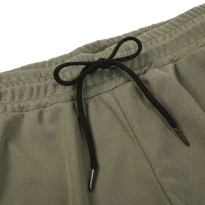 Nahaufnahme der Mesh-Sportshorts mit elastischem Bund und schwarzem Kordelzug.