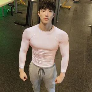 Enges pinkfarbenes Langarm-Sportshirt für Herren an einem asiatischen Fitness-Model