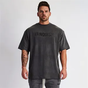 Detailweergave van het gewassen grijze oversized fitness T-shirt met Vanquish-print op de borst.