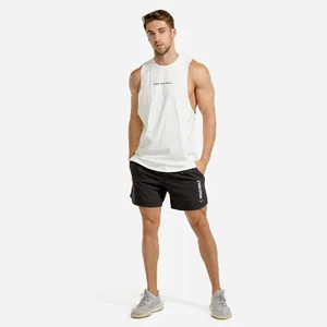 Full view of white men's fitness tank top and black gym shorts on professional male model