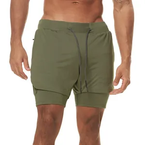 Detalle de pantalones cortos deportivos de doble capa verde oliva para hombre con malla.