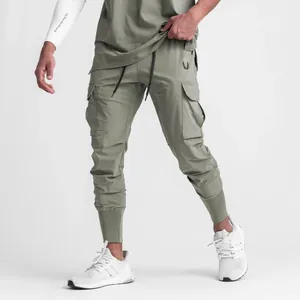 Vue détaillée du pantalon cargo de sport pour hommes vert olive avec poignets fuselés et poches