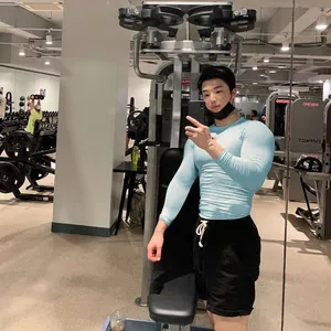 Nahaufnahme des hellblauen Langarm-Kompressionsshirts am Fitnessmodel im Fitnessstudio