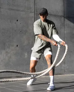 Athletic man wearing breathable double-layer sports shorts during outdoor rope workout