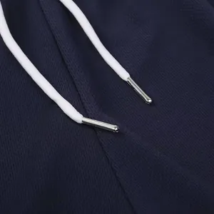 Detailansicht des weißen Kordelzugs mit Metallspitzen an dunkelblauen Mesh-Sportshorts