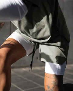 Close-up of olive green 2-in-1 running shorts for men featuring white compression layer