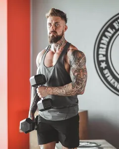Muscular male athlete wearing a gray breathable elastic sports tank top in gym