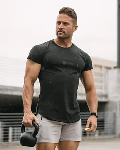 Close-up of a muscular man wearing a tight black training T-shirt in rainy outdoor setting