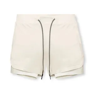 Detalle de pantalones cortos deportivos de doble capa para hombre en crema