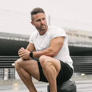 Muscular fit white gym t-shirt for men shown in an outdoor fitness setting