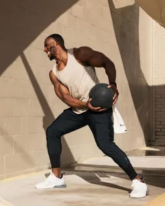 Détail du pantalon cargo de fitness noir porté par un athlète lors d'un entraînement