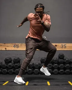 Professional action shot of slim-fit brown cargo workout pants for men during gym training