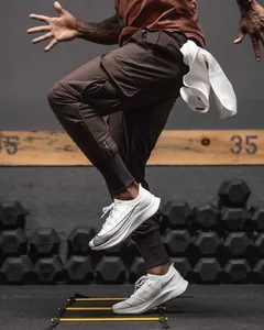 Action detail view of men's slim fit brown cargo joggers during intensive gym training