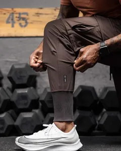 Close-up of brown slim fit cargo joggers showing high elasticity and ribbed cuffs