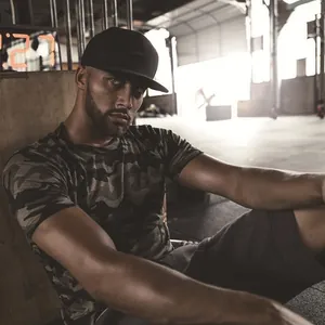 Close-up detail of a men's camouflage fitness t-shirt showing the muscle fit and texture