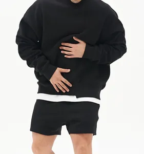 Detalle de la sudadera negra de cuello redondo oversize con diseño de dobladillo blanco