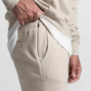 Detailansicht der beigen Sporthose für Herren mit einer versteckten Reißverschlusstasche