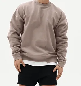 Detalle de sudadera oversize de cuello redondo para hombre en color topo con costura frontal