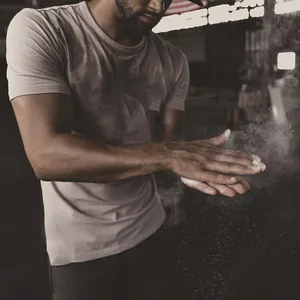 Detailed shot of a man wearing a slim fit athletic t-shirt in a gym setting with chalk