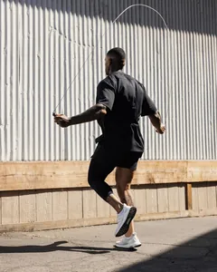Detail shot of men's mesh fitness shorts during an outdoor rope jumping workout session