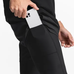 Détail de la poche de téléphone cachée sur un short de sport noir 2-en-1 pour homme.