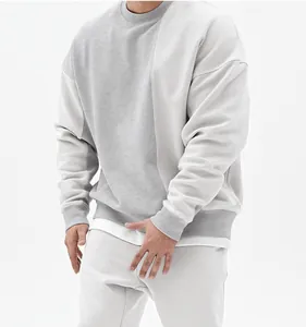 Primer plano de sudadera gris minimalista de corte oversize con costuras de hombros caídos.