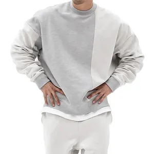Detalle de una sudadera de cuello redondo para hombre, estilo oversize y diseño bicolor