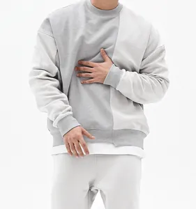 Vista detallada de una sudadera gris oversize para hombre con cuello redondo y diseño.