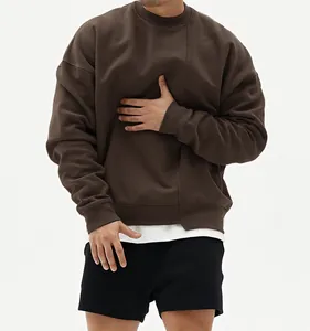Vista detallada de sudadera cuello redondo marrón oscuro oversize con panel texturizado