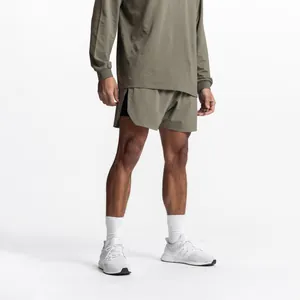 Detailed view of men's olive green athletic shorts with side slits for gym training.