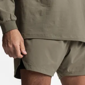 Close-up detail view of olive green men's gym shorts featuring side split and layered design