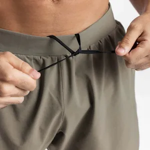 Close-up of olive green athletic shorts featuring adjustable drawstring waistband detail