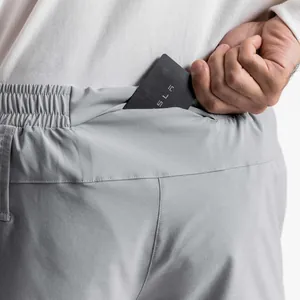 Detalle del bolsillo trasero oculto de pantalones cortos deportivos grises para hombres