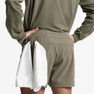 Close-up of men's olive green athletic shorts featuring a practical back towel loop detail