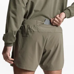 Detail shot of olive green men's athletic shorts featuring a functional rear pocket
