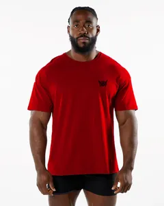 Athletic men's red crew neck fitness t-shirt with chest logo on model in studio