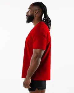 Side profile view of a muscular man wearing a vibrant red athletic short-sleeve t-shirt.