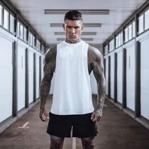 Primer plano de hombre musculoso con camiseta blanca transpirable en un pasillo largo.